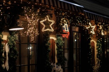 Şık bir noel yıldızı aydınlatması ve akşamları altın ışıklarda ladin dalları, peri masalı süslemeleri. Atmosferik sihir zamanı. Şehir sokaklarında kış tatili için Noel dekorasyonu