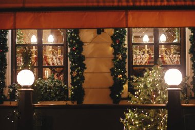 Şık noel ladin dalları altın ışıklarla aydınlatılıyor akşamları pencerelere. Atmosferik sihir zamanı. Kış tatilleri için Noel dekorasyonu. Mutlu Noeller.!