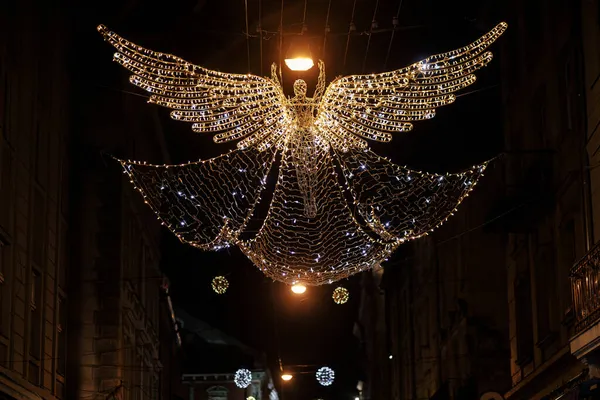 暗い空を背景に照らされたスタイリッシュな美しいクリスマス天使 大気魔法の時間だ 街の通りで冬の休日のためのクリスマスのお祝いの装飾 メリークリスマス — ストック写真