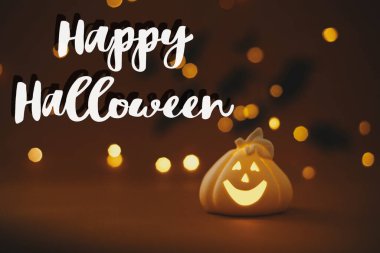 Turuncu arka planda parlayan Jack o fener kabağı ve uçan siyah yarasalarla ilgili Cadılar Bayramı mesajınız kutlu olsun. Sezonun tebrik kartı. El yazısıyla mutlu Cadılar Bayramı metni