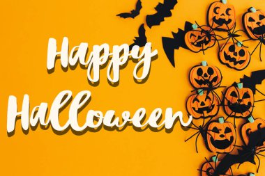 Balkabaklarının, fenerlerin, örümceklerin, yarasaların turuncu arka planda yattığı Cadılar Bayramı tabelası kutlu olsun. Sezonun tebrik kartı. El yazısıyla mutlu cadılar bayramı mesajı. Şaka mı şeker mi?