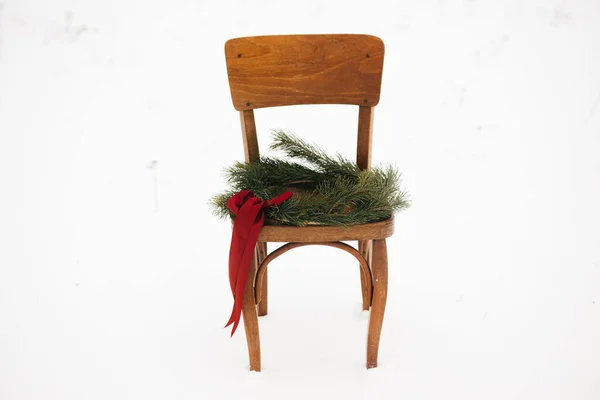눈내리는 들판의 의자에 크리스마스 화환을 걸었습니다 크리스마스 시골에서의 문자를 의자에 — 스톡 사진