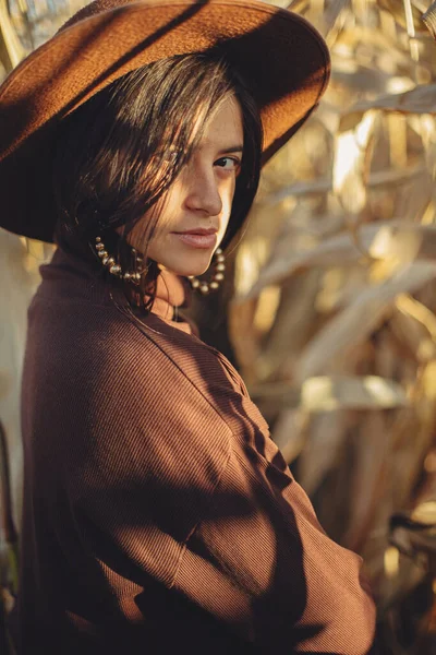 Stylowa Kobieta Kapeluszu Brązowe Ubrania Pozowanie Jesiennym Polu Kukurydzy Ciepłym — Zdjęcie stockowe