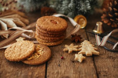 Noel yulaf ezmeli kurabiyeler ve sade ahşap masa süsleri. Atmosferik Noel karamsar görüntüsü. Xmas sağlıklı kurabiyeler ve süsler. Mutlu Noeller ve mutlu Noeller.