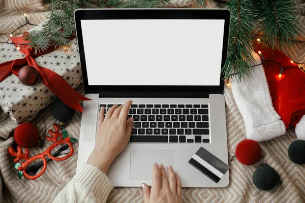신용카드로 침대에 화면을 노트북에 크리스마스 모자를 넣는다 크리스마스 온라인 쇼핑이요 — 스톡 사진