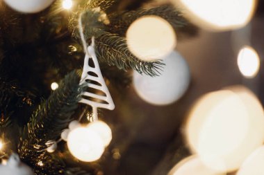 Modern cam Noel süsleri, beyaz takılar ve altın noel ışıkları yaklaştı. Mesaj için yer var. Atmosferik şenlik dekore edilmiş İskandinav odası. Şık Noel ağacı dekoru