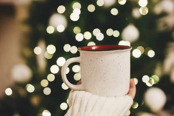 Mão Suéter Segurando Copo Elegante Fundo Árvore Natal Luzes Sala — Fotografia de Stock