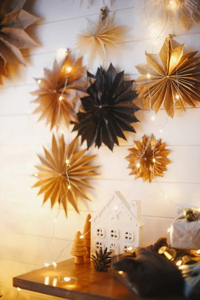 スタイリッシュなクリスマスの小さな家や木 紙の星と黄金の光と白い壁を背景に木製の棚の上のプラスチックフリーギフト お祝いの装飾されたスカンディナヴィアの部屋 Eve — ストック写真
