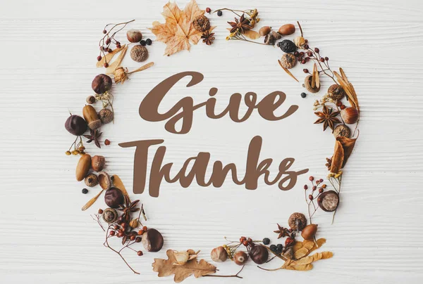 白い木の上に秋の花輪フラットレイアウトに感謝のテキストを与えます ハッピー感謝祭季節のグリーティングカード 手書きのサイン 感謝祭の挨拶 — ストック写真