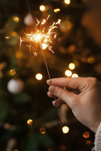 Ruka Drží Hořící Jiskru Pozadí Vánoční Stromeček Světla Slavnostní Večerní — Stock fotografie