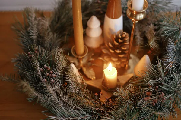 圣诞花圈里燃烧着时尚的蜡烛 在喜庆的房间里 在白墙的背景下 木桌上用松果和树装饰着 圣诞节来了大气冬季假期 — 图库照片