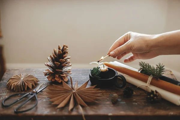 Hand Lighting Stylish Christmas Candle Paper Stars Pine Cones Fir — Stock Photo, Image