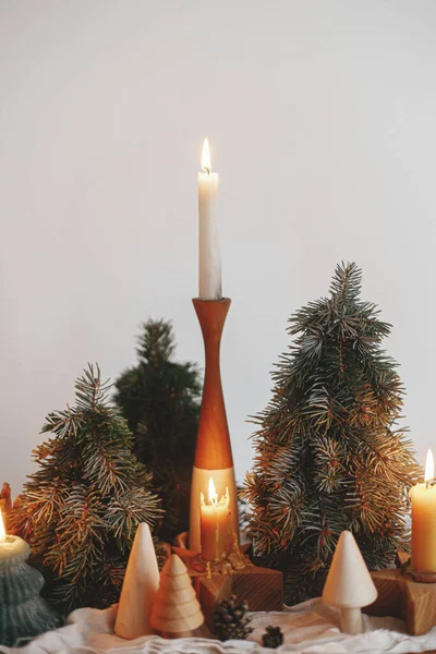 假期来了现代鸟类节日期间 在白色墙壁的背景下 木制桌子上挂着时尚的圣诞蜡烛和松树装饰 大气冬季 — 图库照片