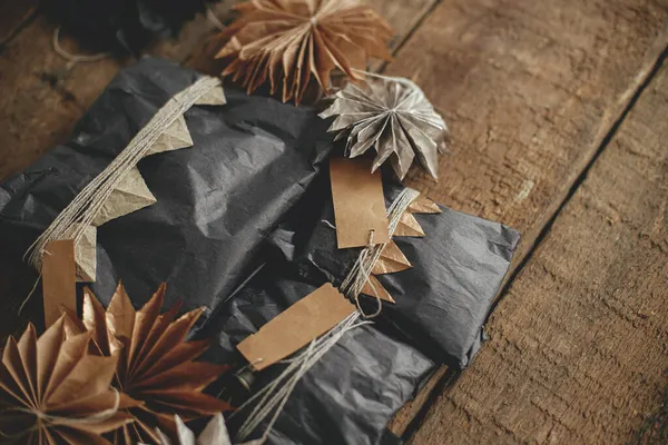 Elegantes Regalos Navidad Envueltos Papel Artesanal Negro Con Etiquetas Estrellas —  Fotos de Stock