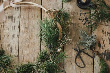 Modern noel çelengi düzdü. Ladin dallı, otlu, makaslı, mumlu, kır ağacında çam kozalaklı ksenli çelenkler. Huysuz bir görüntü. Mutlu Noeller! Kış tatili hazırlığı