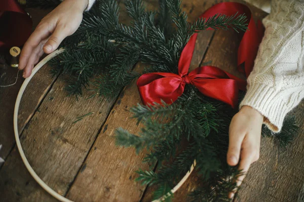 Hände Halten Einen Modernen Weihnachtskranz Mit Tannenzweigen Und Roter Schleife — Stockfoto