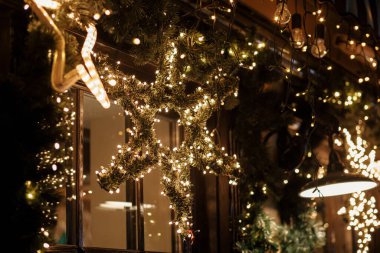 Şık bir noel yıldızı aydınlatması ve akşamları altın ışıklarda ladin dalları, peri masalı süslemeleri. Atmosferik sihir zamanı. Kış tatilleri için Noel dekorasyonu. Mutlu Noeller.!