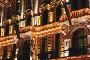 Akşamları eski binanın üzerinde şık noel ışıkları, peri masalı süslemeleri. Atmosferik sihir zamanı. Şehir caddesinde kış tatili için Noel dekorasyonu. Mutlu Noeller.!