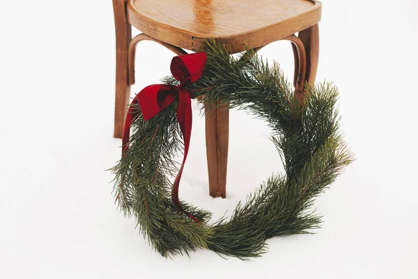 크리스마스 눈내리는 들판의 의자에 크리스마스 화환을 걸었습니다 시골에서의 Xmas 소나무 — 스톡 사진