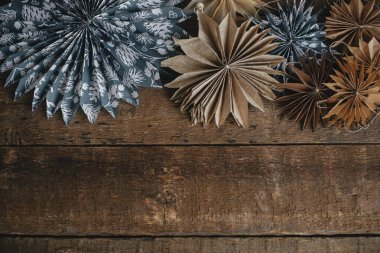 Mutlu Noeller! Noel yıldızları sade ahşap masa yatağında yatar. Mesaj için yeri olan bir tebrik kartı. Paket kağıdından yapılmış Noel yıldızları