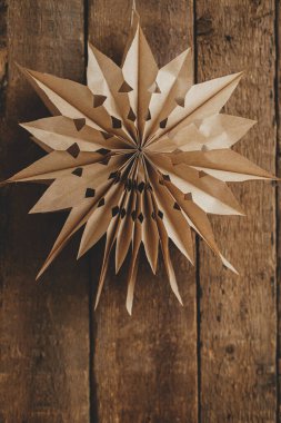 Eski ahşap arka planda asılı şık kağıt Noel yıldızı. Mevsimin tebrik kartı ve mesaj için yeri var. Modern İsveç kağıt yıldızı. Mutlu Noeller ve mutlu tatiller!