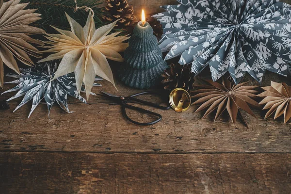 スタイリッシュな紙のクリスマススター キャンドル 素朴な木製のテーブルの上の装飾品の国境 テキスト用スペース付きシーズングリーティングカード メリークリスマスとハッピーホリデー スカンジナビアのムーディイメージ — ストック写真