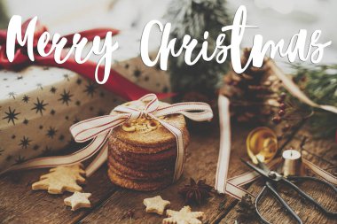 Mutlu Noeller tebrik kartı. Kurabiyelerle ilgili mutlu noel metinleri, şık hediyeler, köy masasında şenlikli dekorasyonlar. Atmosferik xmas bileşimi. İyi tatiller! El yazısı işareti