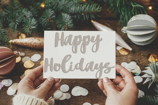 手やクリスマスの装飾品 装飾品 コンフェクト 枝のグリーティングカード上の幸せな休日のテキスト シーズンの挨拶カード 手書きのサインだ メリークリスマス — ストック写真