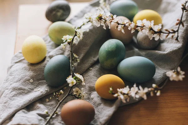 复活节快乐 复活节彩蛋放在带有樱花的乡村餐桌上 在乡村房间内的亚麻布餐巾和春花上 天然染色彩蛋 乡村静谧的生活 大气图像 — 图库照片