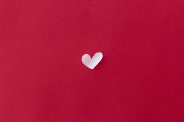 Sevgililer Günün kutlu olsun! Valentine 'ın kalbi kırmızı arka planda yatıyordu. Mesaj için boşluk vardı. Sevgililer Günü kartı çok az. Kırmızı kağıtta kesilmiş şirin, küçük beyaz bir kalp. Aşk konsepti