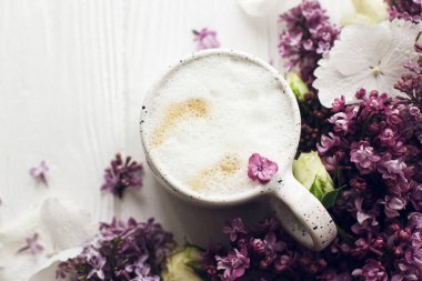 Lezzetli kahve, çiçek açan leylak dalı ve kırsal beyaz ahşap arka planda gül. Merhaba bahar. Metin için yeri olan düz bir yer. Anneler Günün kutlu olsun. Günaydın natürmort