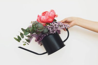 Merhaba bahar. Beyaz arka planda zarif metal sulama kutusu şakayık, leylak çiçekleri ve okaliptüs düzeneği. Anneler Günün kutlu olsun ya da Sevgililer Günü. Çiçek dükkanı.