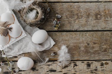 Paskalya kırsalı düzlüğü, yazı için boşluk. Tepside doğal yumurtalar, tüyler, söğüt dalları, eski ahşap masaya yuva. Paskalya kırsalındaki şık yaşam. Basit bir estetik. Mutlu Paskalyalar