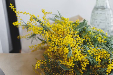 Ahşap arka planda şık bir mimoza buketi. Merhaba bahar. Kırsal pencere kenarında el işi kağıdında güzel mimoza çiçekleri. Mutlu kadınlar günü ve mutlu anneler günü. 8 Mart kavramı
