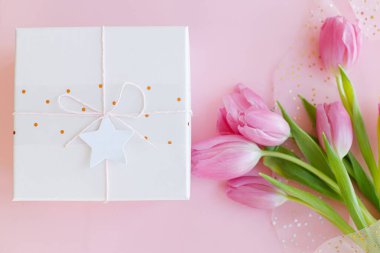 Pembe lale buketi ve pembe arka planda bir hediye kutusu. Mutlu kadınlar günü. 8 Mart. Anneler Günün kutlu olsun. Tebrik kartı. Yumuşak resim