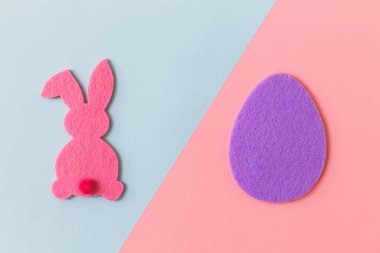 Mutlu Paskalyalar! Mor ve pembe arka planda renkli Paskalya yumurtası ve tavşanı, mesaj için yeri olan düz bir yer. Mor ve pembe yapay yumurta ve tavşan dekoru. Yaratıcı Paskalya avı kavramı