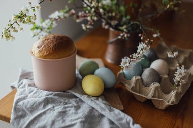Ev yapımı paskalya ekmeği, doğal boyanmış yumurtalar ve kırsal masada bahar çiçekleri. Mutlu Paskalyalar! Yeni pişmiş Paskalya pastası, geleneksel Ukrayna çöreği.