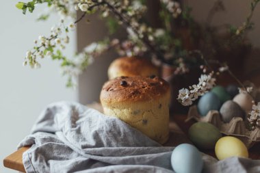 Mutlu Paskalyalar! Ev yapımı paskalya ekmeği, doğal boyanmış yumurtalar ve kırsal masada bahar çiçekleri. Yeni pişmiş Paskalya pastası, geleneksel Ukrayna çöreği.