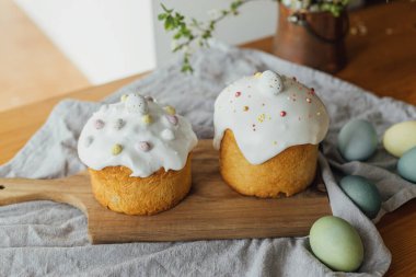 Mutlu Paskalyalar! Ev yapımı paskalya ekmeği, doğal boyanmış yumurtalar ve kırsal masada bahar çiçekleri. Şekerli ve serpiştirilmiş taze paskalya pastası, geleneksel Ukrayna çöreği.
