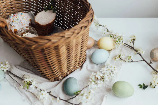 复活节快乐 带着春花和柳条筐的乡村餐桌上的美味的东方面包和天然染过的鸡蛋 传统的复活节篮子食物 带有糖霜 鸡蛋的复活节蛋糕 — 图库照片