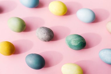 Paskalya kompozisyonu. Kaliteli yumurtalar pembe arka planda yatıyordu. Modern doğal renklerle boyanmış Paskalya yumurtaları güneşli ışık ve gölgede. Tebrik kartı, Paskalya arkaplanı