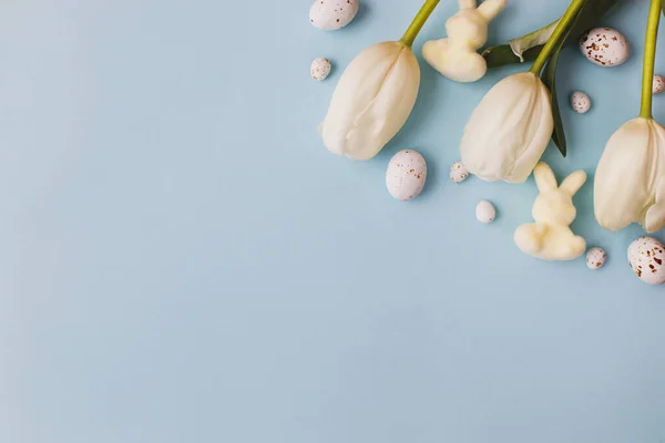 Modrém Pozadí Ležela Stylová Velikonoční Vajíčka Tulipány Zajíčci Moderní Čokoládová — Stock fotografie