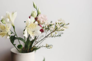 Vitrindeki seramik vazoda şık bir buket. Güzel taze çiçekler, Manuka, alstroemeria, Eustoma, okaliptüs çiçeği aranjmanı. İlkbahar modern buketi yakın çekim