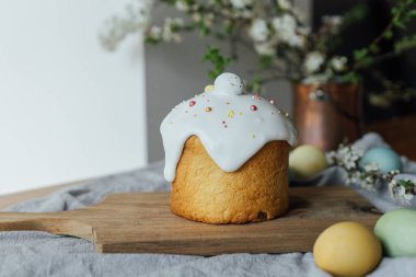 Mutlu Paskalyalar! Ev yapımı paskalya ekmeği, doğal boyanmış yumurtalar ve kırsal masada bahar çiçekleri. Şekerli ve serpiştirilmiş taze paskalya pastası, geleneksel Ukrayna çöreği.