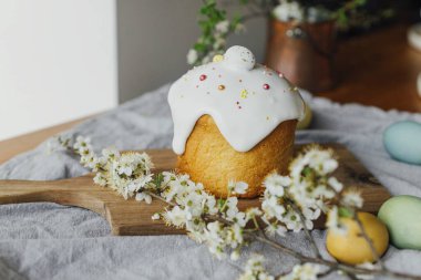 Mutlu Paskalyalar! Ev yapımı paskalya ekmeği, doğal boyanmış yumurtalar ve kırsal masada bahar çiçekleri. Şekerli ve serpiştirilmiş taze paskalya pastası, geleneksel Ukrayna çöreği.