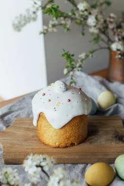 Mutlu Paskalyalar! Ev yapımı paskalya ekmeği, doğal boyanmış yumurtalar ve kırsal masada bahar çiçekleri. Şekerli ve serpiştirilmiş taze paskalya pastası, geleneksel Ukrayna çöreği.