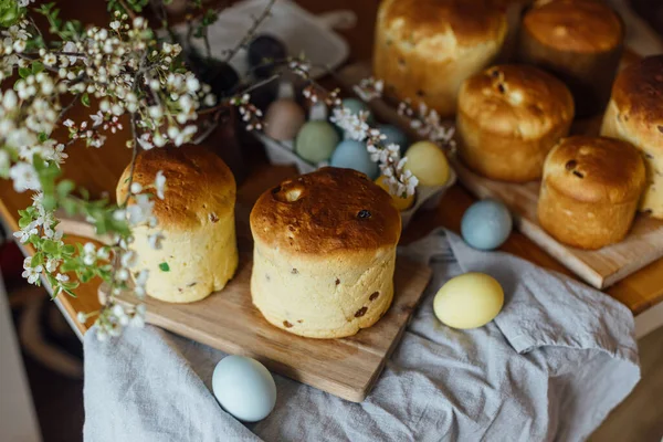 Homemade easter breads, natural dyed eggs and spring blossom on rustic table in room. Happy Easter! Freshly baked easter cakes, traditional ukrainian bun