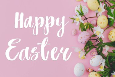 Mutlu Paskalya tebrik kartları. Mutlu Paskalya metinleri ve renkli Paskalya çikolataları ve bahar çiçekleri pembe arka planda yatıyordu. Mevsimlik tebrik kartı, el yazması mektuplar.