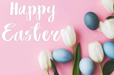 Mutlu Paskalya tebrik kartları. Mutlu Paskalya metinleri ve modern Paskalya yumurtaları, laleler ve tavşanlar pembe arka planda yatıyordu. Mevsimlik tebrik kartı, el yazması mektuplar..