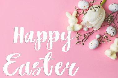 Mutlu Paskalya tebrik kartları. Mutlu Paskalya metinleri ve modern yumurtalar, laleler, tavşanlar pembe arka planda yatıyordu. Mevsimlik tebrik kartı, el yazması mektuplar.